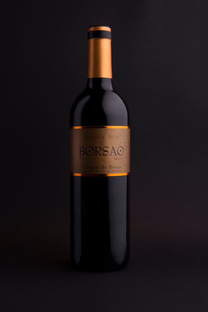 A minimalist shot of a Borsao wine bottle with a gold label on a dark backdrop.